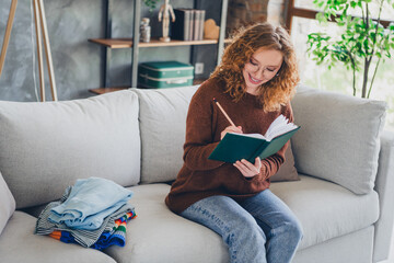 Photo of pretty lovely cute woman sit sofa living room checking online order clothes indoors house...