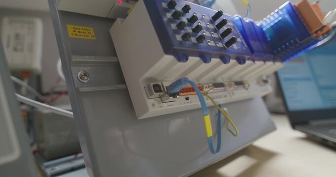 Parallax shot of a caucasian hand holding an ethernet cable, cabe gets plugged into an electronic device. cable gets pulled out at the end of the shot.