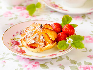 Cream puffs cakes or profiterole filled with whipped cream and served with strawberries and tea on the table
