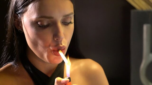 Young beautiful female fashion model smoke the cigarette. pretty woman wears elegant black clothes and reads the book