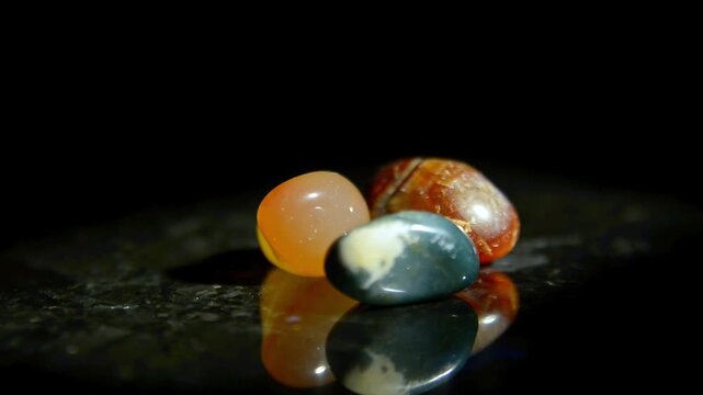 different colorful Semi Precious stones on dark polished stone surface 
