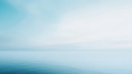 A serene view of a calm ocean under a soft blue sky.