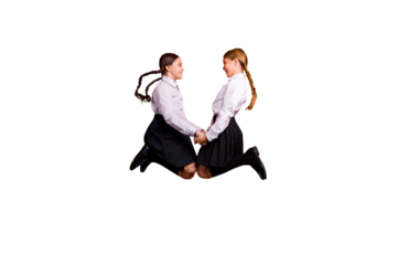 Full length body size profile side view of two person nice attractive charming cute excited cheerful pre-teen girls having fun jumping up holding hands isolated on bright vivid shine orange background