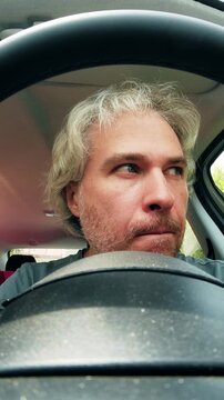 A funny suspicious male driver in the car, vertical video