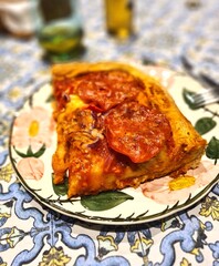 evocative image of a slice of homemade pizza made with spicy salami, 
tomato sauce, mozzarella and onions ready to be savored