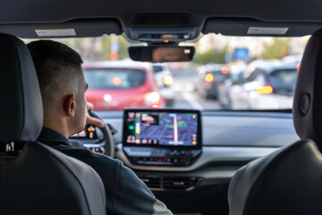 Man touching screen of a GPS navigation system in his car.