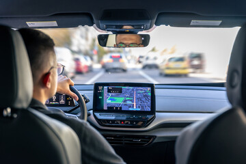 Man touching screen of a GPS navigation system in his car.