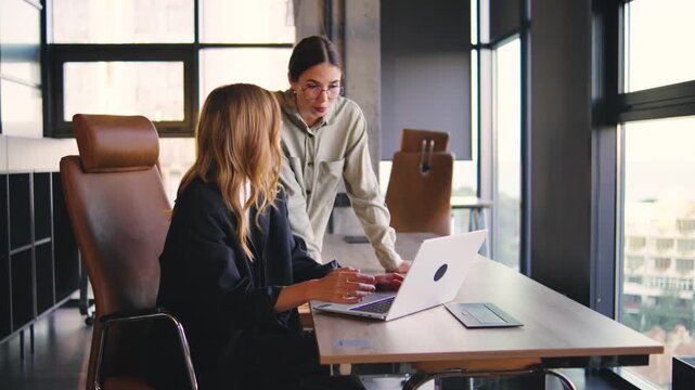 In this collaborative workspace, two professionals engage in a stimulating discussion about their project, exchanging innovative ideas and brainstorming effective solutions to challenges
