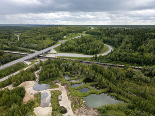 Road Bridge Over Freight Railroad Trains Among Forest and Roads