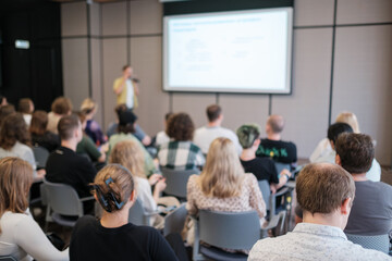 Business professionals gathered at seminar listening to a presentation in a conference room