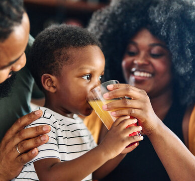 child family kitchen boy son mother father drink breakfast juice healthy fruit food drinking thirsty eating glass home black african american childhood cute love bonding
