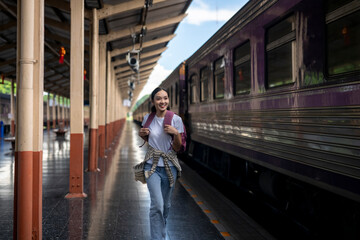 A woman is running to catch a train at a train station