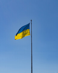 the flag flutters in the blue sky