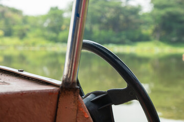 Close-Up of a Boat Steering Wheel with Lake View