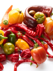 tomatoes and different peppers isolated on white background
