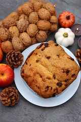 Raisin fruit cake dessert traditional pastry dried fruits, nuts, apples, cones and candles on dark grey background with copy space. Autumn menu ideas. 