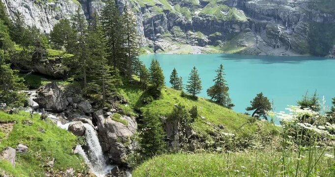 Oeschinensee Lake hike in Switzerland, near Kandersteg in the Swiss Alps. Waterfall