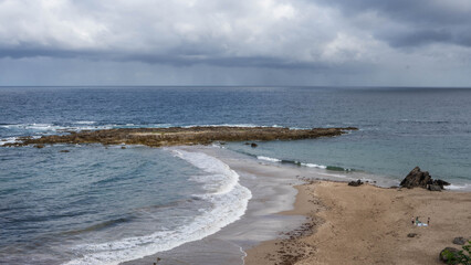 Playa salvaje en Asturias donde se ve un conjunto de piedras que se niega a ser engullido por el mar