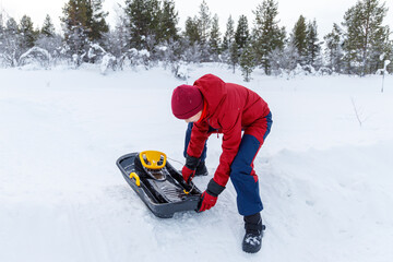 Girl preparing the sled for sliding on the snow
