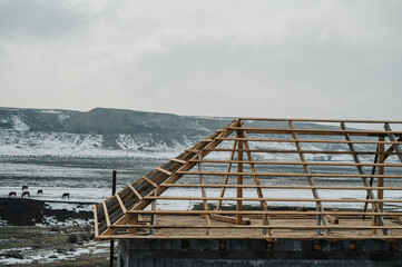 A panoramic close-up shot of the roof of a house under construction against a blue sky background.
