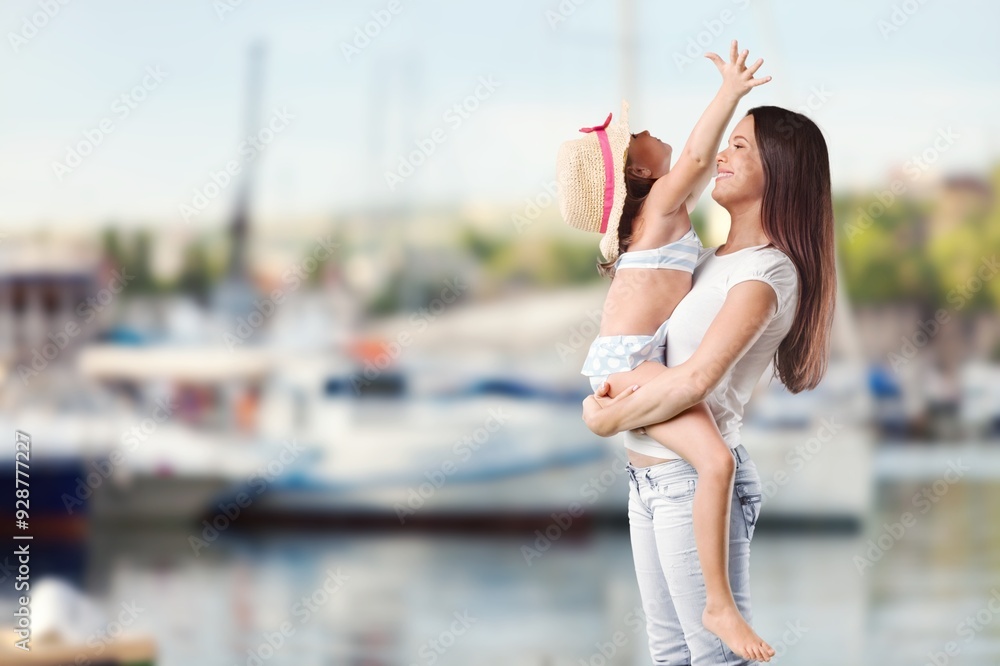 Wall mural Smiling young happy mother and beautiful child at the beach