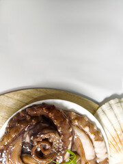 Fresh octopus on a white plate ready for cooking. Seafood on white background