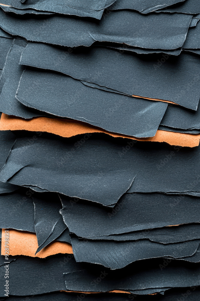 Poster stacked torn paper sheets with layers of dark and orange colors, creating a textured and abstract ba