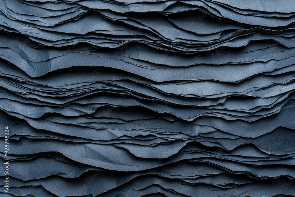 Poster close-up view of multiple layers of dark blue textured paper, showcasing abstract patterns and detai