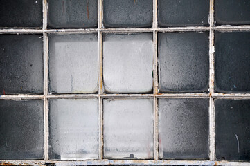 A gridded old window with opaque glass panes no people