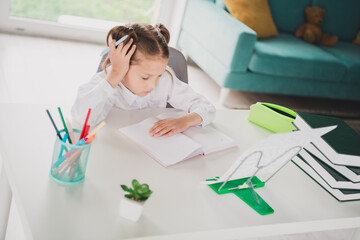 Photo portrait of cute small schoolgirl minded tired do homework home education concept school interior