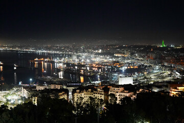 Obraz premium Focus on the lit buildings of the large city of Algiers in this nighttime shot of the Port of Algiers on the Mediterranean Sea.
