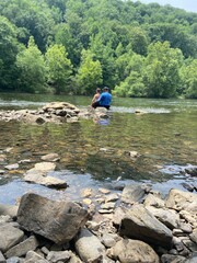 Dad and Son sitting on a rock at the river