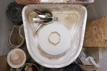 Light airy air dried clay on a spinning pottery wheel from above , making pottery out of clay mud. close up photograph with a shallow depth of field.Creamy textured pot.