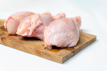 Fresh Raw chicken Drumsticks on cutting board isolated on a white background.