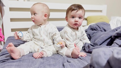 happy family childhood dream concept. little girl and boy sit on a soft bed in sliders and look...