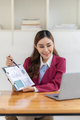 Asian businesswoman accountant uses calculator to calculate financial graph showing investment results Plan your business growth process for success. Vertical format.