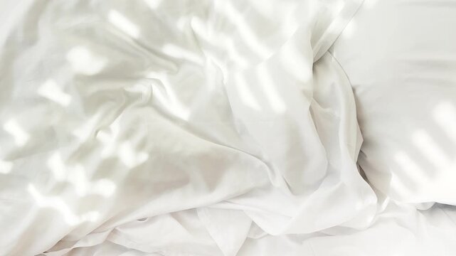 The sun light from the window fall on the white bed in the bedroom in the morning, the shadow lines from the curtain, blurry shad