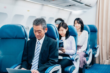 飛行機で出張に出かけるミドルのビジネスマン
