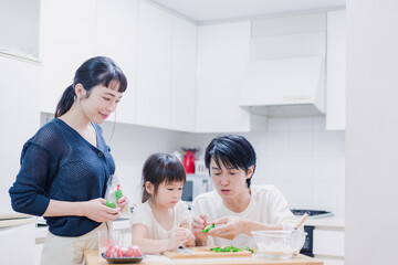 子供と一緒にクッキングをする家族