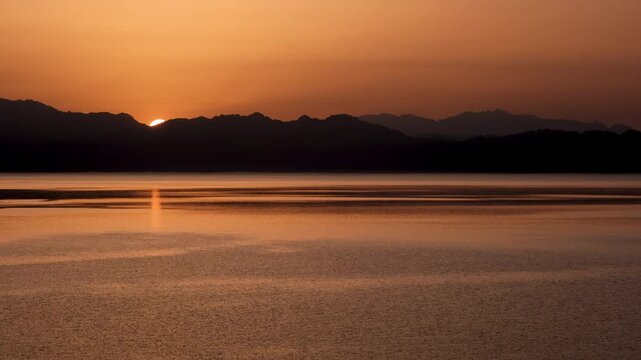 Time lapse of sun rising above Gulf of Aqaba of Red Sea and Saudi Arabia's mountains. View from Dahab, Egypt.