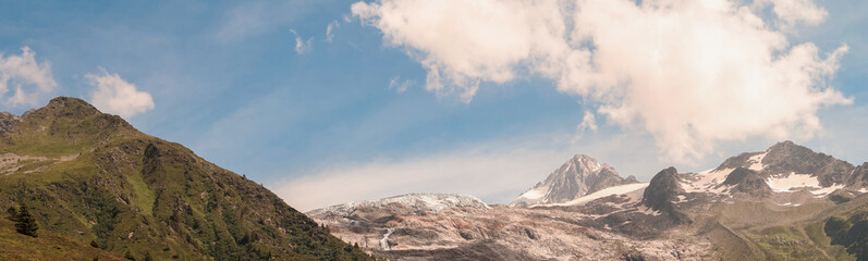 Panoramic View Of Mountain Landscape Showing Glacier Melting Under Blue Sky With Clouds