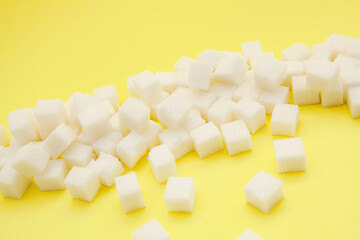 White sugar cubes on bright yellow color, card with food background