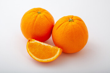Fresh two whole orange fruit and one segment.