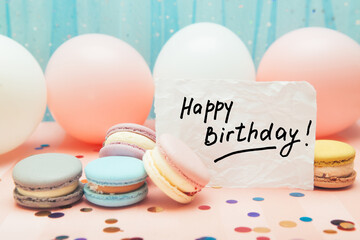 Happy birthday - card with text and colorful macarons, air balloons and pastel color decoration