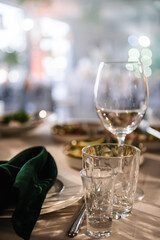 Luxury table settings for fine dining with glassware, and blurred background for event. Preparation for holiday props for wedding, birthday, and celebration. Empty glasses set in restaurant.
