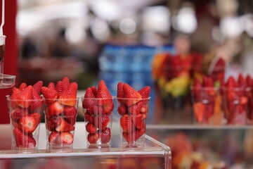 Fresh strawberries in cups at a market stall