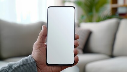 Man holding a blank screen mobile phone in his hand in a closeup photo. His hands are using a smartphone