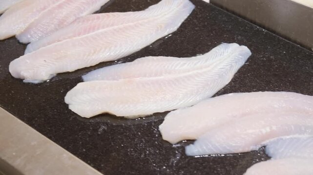 Fresh raw fish cod fillet on counter close-up.