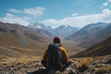 Fototapeta premium A traveler rests, taking in an awe-inspiring mountain view.