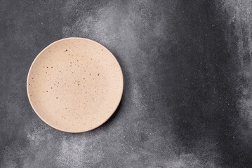 Empty ceramic plate on a dark textured background